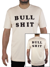 Man wears light beige t-shirt with the words "BULL SHIT" on the front.  There is a photo inset in bottom right corner, showing the back of the shirt, which also says "BULL SHIT."
