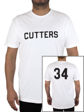 Man wears white t-shirt with block letters across chest reading "CUTTERS."  Bottom right corner has an inset photo of the back of the shirt, showing a large number 34 printed in black.